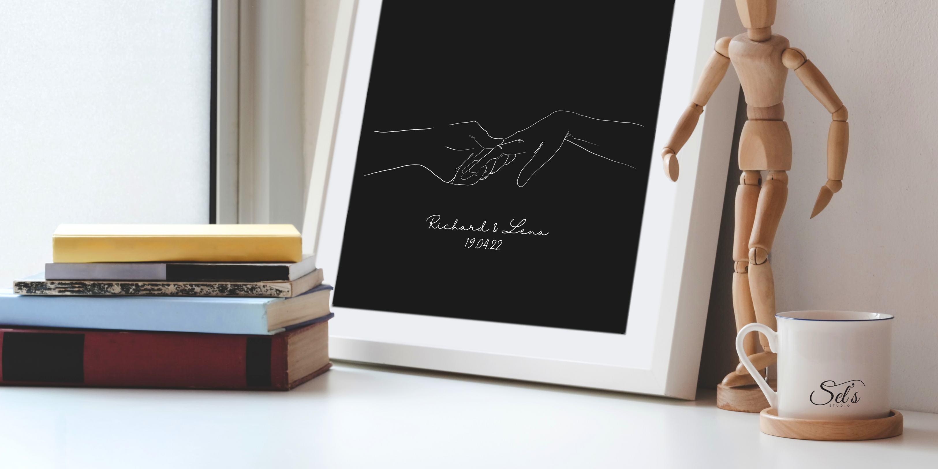 Line Art Illustration eines sich haltenden Paares mit Namen und Datum – personalisiertes Kunstwerk von Sels Studio, inszeniert auf einem stilvollen Arbeitsplatz mit Logo-Tasse und Künstlerfigur